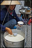 Woman serving a bowl of soft tofu. Ho Chi Minh City, Vietnam (color)