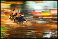 Motorcycle riders, water splashes, and streaks of light. Ho Chi Minh City, Vietnam (color)