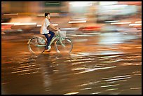 Night Bicyclist, water, and motion light streaks. Ho Chi Minh City, Vietnam