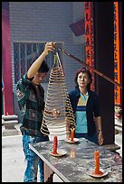 Man getting ready to hang incense coil, Thien Hau Pagoda, district 5. Cholon, District 5, Ho Chi Minh City, Vietnam ( color)
