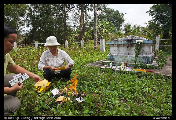 Women burning fake money as offering. Ben Tre, Vietnam