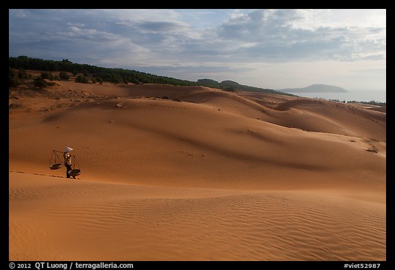 Coastal sand dunes with sea in distance and local woman. Mui Ne, Vietnam