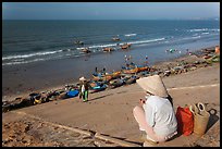 Woman on stairs overlooking beach with fishing boats. Mui Ne, Vietnam ( color)