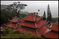 Temple rooftop overlooking plains in mist. Ta Cu Mountain, Vietnam (color)
