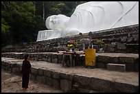 Woman prays below reclining Buddha statue. Ta Cu Mountain, Vietnam ( color)