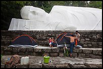 Pilgrims pitch tent below reclining Buddha statue. Ta Cu Mountain, Vietnam (color)