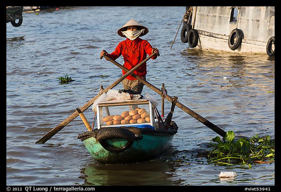 Woman paddling boat with breads, Cai Rang floating market. Can Tho, Vietnam (color)