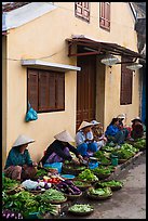 Vegetable vendors sitting in front of old house. Hoi An, Vietnam (color)