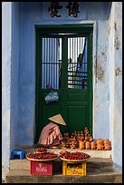 Ceramics vendor, blue temple door. Hoi An, Vietnam (color)