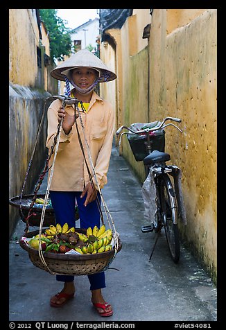Fruit vendor carrying bananas. Hoi An, Vietnam