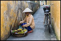 Fruit vendor in narrow alley. Hoi An, Vietnam (color)