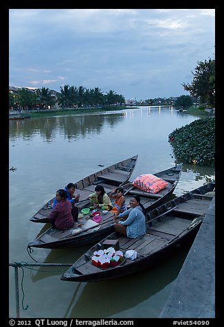 Family having dinner on boats at dusk. Hoi An, Vietnam
