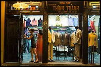 Woman closing doors of taylor shop. Hoi An, Vietnam ( color)