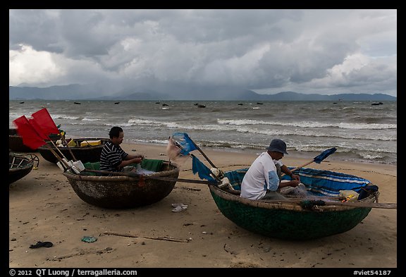 Fishermen mending nets in coracle boats. Da Nang, Vietnam