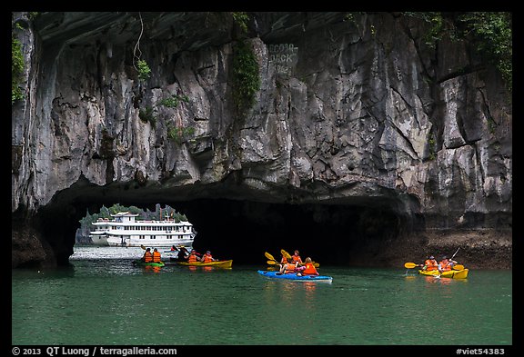 Kayaks floating through Luon Can tunnel. Halong Bay, Vietnam