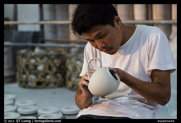 Man assembling ceramic tea pot in workshop. Bat Trang, Vietnam