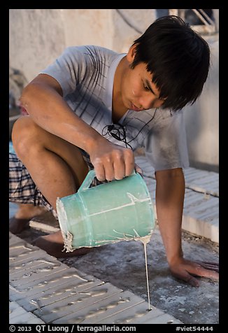 Man pouring clay into molds in ceramic workshop. Bat Trang, Vietnam (color)