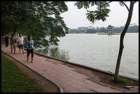 Walking for exercise around Hoang Kiem Lake at dawn. Hanoi, Vietnam ( color)
