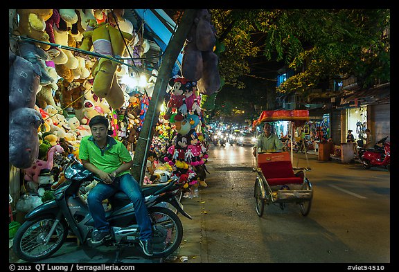 Street at night with motorcycle and cyclo, old quarter. Hanoi, Vietnam