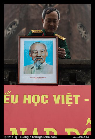 Officer hanging a picture of Ho Chi Minh, Hanoi Citadel. Hanoi, Vietnam (color)
