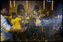 Revellers celebrating with spray in front of Notre Dame Cathedral on Christmas Eve. Ho Chi Minh City, Vietnam (color)