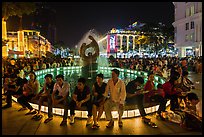 People sitting on fountain at night, New Year eve. Ho Chi Minh City, Vietnam ( color)