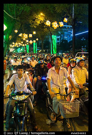 Street packed with motorbikes and bicycle riders at night. Ho Chi Minh City, Vietnam