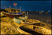 Coracle boats and fishing fleet at night. Mui Ne, Vietnam (color)