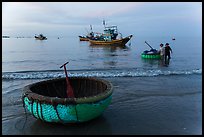 Coracle and fishing boats at dawn. Mui Ne, Vietnam (color)