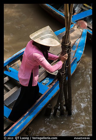 Woman in Ao Ba Ba holding from boat to bamboo poles. My Tho, Vietnam (color)