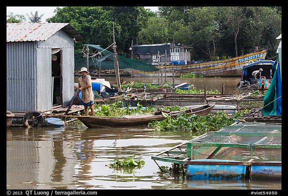 Man paddling out of houseboat. My Tho, Vietnam (color)