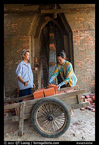 Workers loading bricks out of brick oven. Mekong Delta, Vietnam