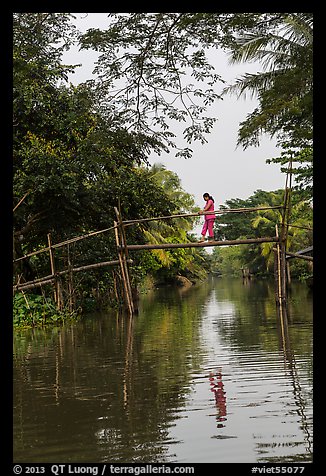 Woman walking across monkey bridge. Can Tho, Vietnam