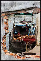 Boat loaded with bricks seen from brick wall opening. Can Tho, Vietnam (color)