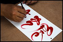 Hands drawing Tet (Lunar New Year) greetings in Chinese characters. Ho Chi Minh City, Vietnam ( color)