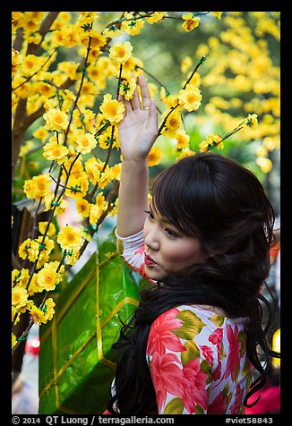 Woman next to Tet (Lunar New Year) decorations. Ho Chi Minh City, Vietnam (color)