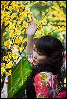 Woman next to Tet (Lunar New Year) decorations. Ho Chi Minh City, Vietnam ( color)