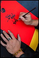 Hands drawing Tet greetings in ornamented characters. Ho Chi Minh City, Vietnam ( color)