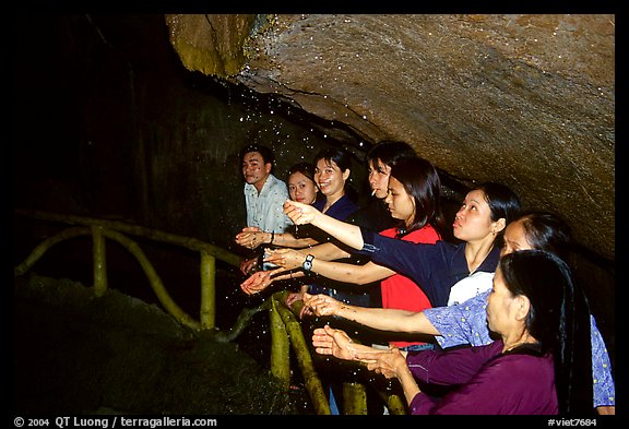 Women catch the water seeping from Tan Thanh Cave, said to have mirculous properties. Lang Son, Northest Vietnam