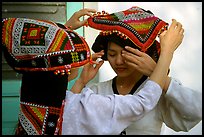 A thai woman helps her friend with her elaborate headdress, Son La. Northwest Vietnam (color)