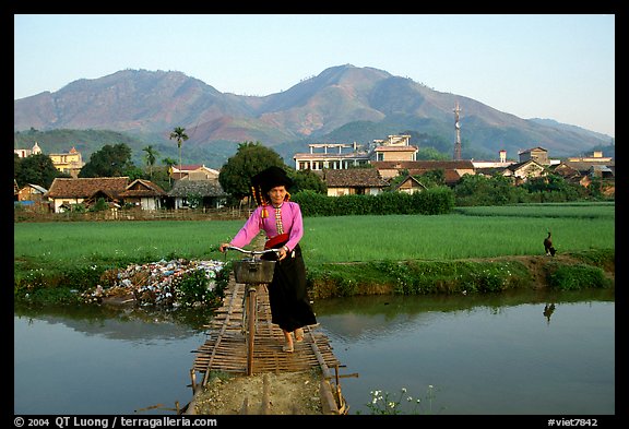 Thai woman pushing her bicycle across a bridge, Tuan Giao. Northwest Vietnam