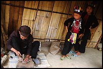 Black Dzao children look at a man  making the decorative coins used on their hats, between Tam Duong and Sapa. Northwest Vietnam