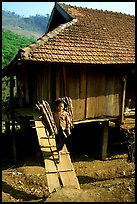 Montagnard child carries logs out of her house, between Tuan Giao and Lai Chau. Northwest Vietnam (color)