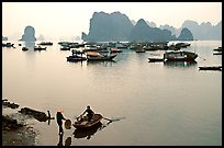 Rowboat meeting woman on shore. Halong Bay, Vietnam