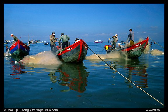 Fishermen get their nets out of their small fishing boats. Vung Tau, Vietnam