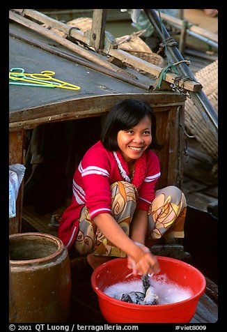 Woman doing laundry on live-aboard boat, the cheapest and most convenient housing in the Delta, near Can Tho. Vietnam