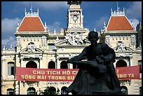 Bronze memorial to Ho Chi Minh by artist Diep Minh Chau and city hall. Ho Chi Minh City, Vietnam