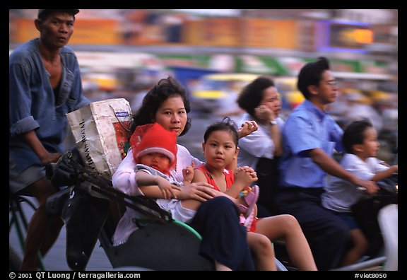 Wheels are seldom for single drivers: families on cyclo and motorbike. Ho Chi Minh City, Vietnam (color)
