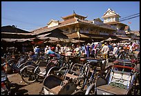 Cyclos wait outside the Bin Tay market in Cholon, district 6. Cholon, Ho Chi Minh City, Vietnam (color)