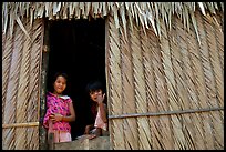 Children pear through a traditional hut. Hong Chong Peninsula, Vietnam ( color)